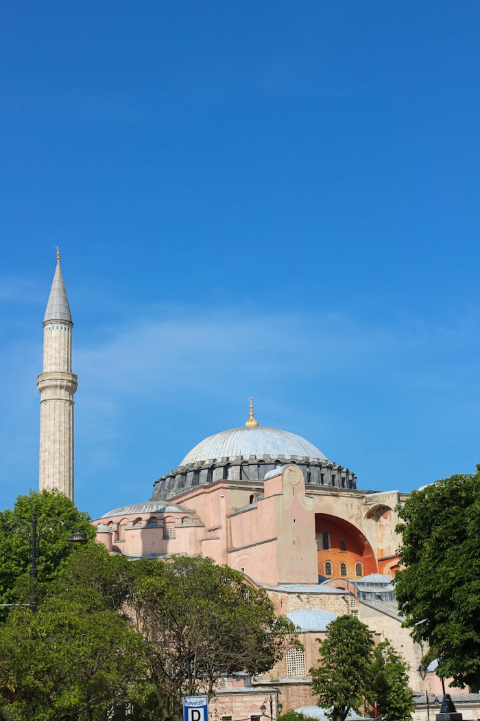 contact Capture of Hagia Sophia's majestic architecture in Istanbul under a clear blue sky.